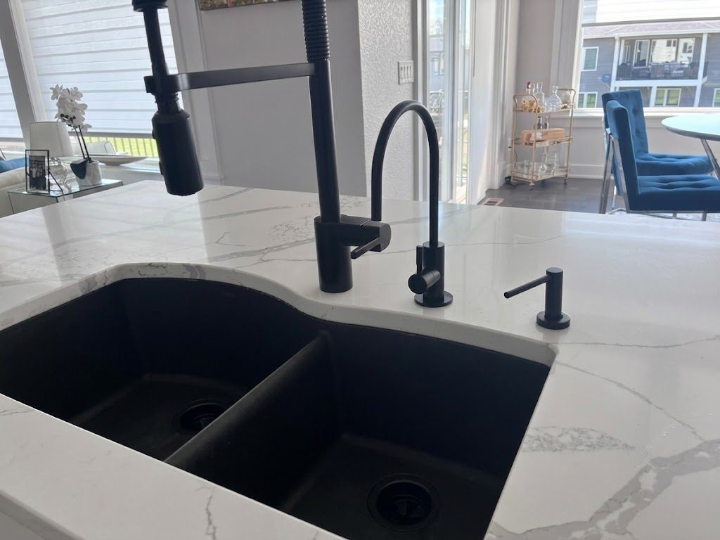 Matte black reverse osmosis drinking water faucet installed on a white quartz kitchen island